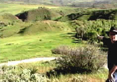 Historian Phillip B Gottfredson in photo pointing at the location where the Diamond Creek BAttle of Spanish Fork Canyon, Utah took place in 1866.